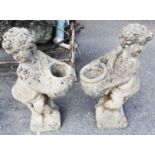 A pair of concrete garden planters in the form of putti holding pots - height 27"