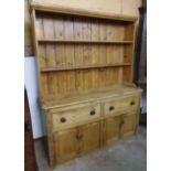 A 5' 2" waxed pine two part dresser with two shelf open plate rack, over a Victorian base with two