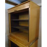 A 3' 3" vintage blonde wood and interior metal framed cabinet enclosed by a tambour