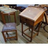 A 16" stained mixed wood vintage child's slope fronted desk with studded rexine upholstered seat