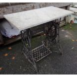 A cast iron Singer sewing machine base with marble table top