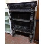 A 35" Victorian ebonised oak two shelf open bookcase with ornate mask and scale carved decoration,