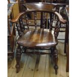 An old stained wood framed smoker's bow elbow chair with moulded solid seat, set on turned supports