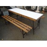 A 5' 10 1/2" folding trestle table - sold with two folding slatted benches to match