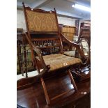 A late Victorian stained and polished framed folding elbow chair with studded tapestry upholstered