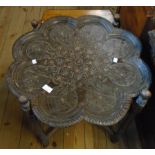 A Middle Eastern hardwood table with studded and carved flowerhead/petal shaped top section, set
