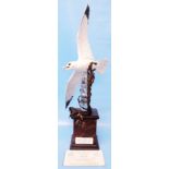 An Albany Fine China limited edition porcelain, glass and bronze model of a kittiwake in flight over