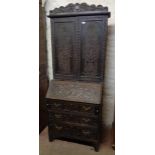 A 33" Victorian heavily carved oak bureau bookcase with adjustable shelves enclosed by a pair of