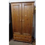 A 3' 1 1/2" modern polished pine wardrobe with hanging space enclosed by a pair of panelled cupboard