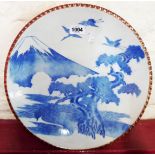A Japanese Arita blue and white porcelain charger depicting cranes flying in front of Mount Fuji,