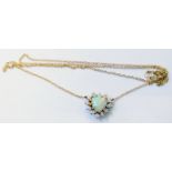 An 18ct. white gold heart shaped pendant necklace, set with central opal within a diamond border, on