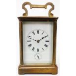 An early 20th Century brass and bevelled glass cased carriage clock with eight day strike/alarm