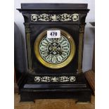 An Edwardian black slate and ivory style mantel clock with flanking canted columns, decorative