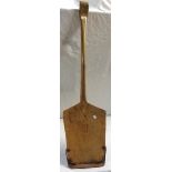 An antique peat shovel with metal blade tip and moulded grip