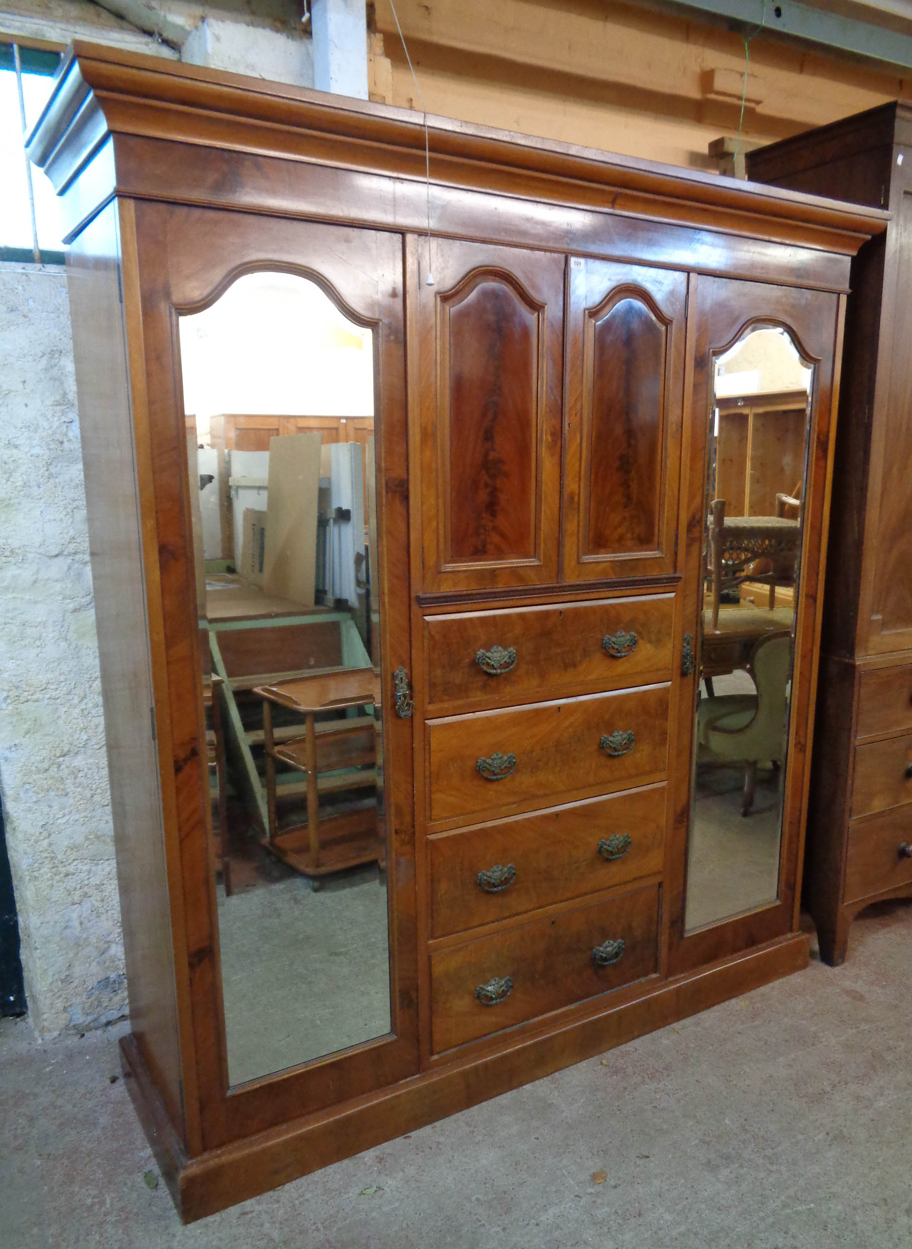 A 6' 2 1/2" late Victorian flame mahogany veneered triple wardrobe with central double cupboard