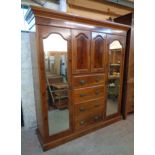 A 6' 2 1/2" late Victorian flame mahogany veneered triple wardrobe with central double cupboard