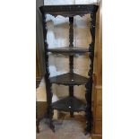 A 27" Victorian ebonised oak three shelf open corner bookcase with carved decoration to top and