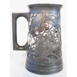 An early 20th Century Chinese Swatow pewter tankard with pierced dragon decoration and cased glass