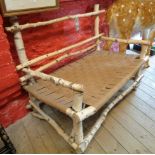 A 3' 8" rustic open arm seat formed from silver birch branches with webbing panel by Greg Hatton