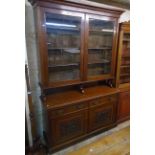 A 5' Edwardian walnut two part book cabinet with scroll pediment moulded top and adjustable