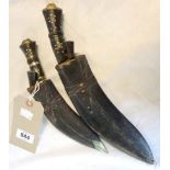 Two souvenir kukri knives in leather scabbards