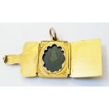 A mid 19th Century yellow metal folding mourning locket with chased decoration and ambrotype image