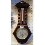 A 1930's stained oak cased barometer/thermometer with flanking open barley twist supports - dial