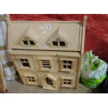A modern unpainted doll's house - sold with a quantity of furniture and accessories