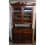 A 3' 11 1/2" Edwardian walnut book cabinet with moulded cornice and adjustable shelves enclosed by a