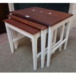 A nest of three stained teak and part painted tea tables