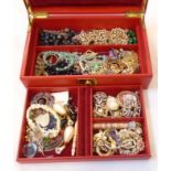 A vintage red leather tray fitted jewellery box containing a quantity of costume jewellery