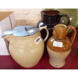 A silicone ware jug with mask spout and pewter lid - sold with a treacle glazed stoneware jug and