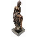 A bronzed seated nude lady set on a black plinth - full height 18"