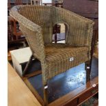 A stained wicker tub chair in the Lloyd Loom style