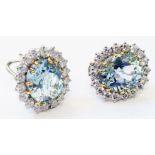 A pair of marked 750 white metal ear-rings, each set with large oval aquamarine within diamond