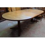 A retro teak extending dining table with two leaves, set on moulded standard ends with swept