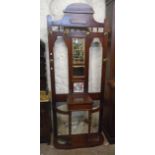 A 33 1/2" Edwardian walnut hallstand with spindle set top, central bevelled mirror, tile and glove