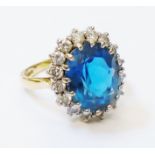 An 18ct. gold ring, set with large oval topaz within a diamond encrusted border