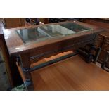 A 3' 3 1/4" 20th Century stained oak display coffee table with bevelled glazed panel to lift-top,