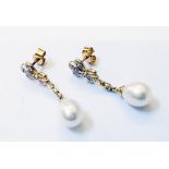 A pair of high carat yellow metal drop ear-rings, each set with single pearl on diamond encrusted