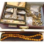 A brown leather effect tray fitted jewellery case containing amber style necklace, dress clips, etc.