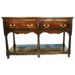 A 4' 7 1/2" Georgian polished oak potboard dresser with two deep frieze drawers and shaped apron,
