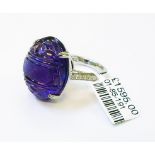 An 18ct. white gold ring, set with large carved cabochon amethyst and diamonds to shoulders