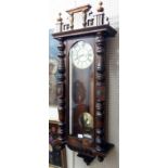 An early 20th Century stained walnut and mixed wood cased Vienna style wall clock with decorative