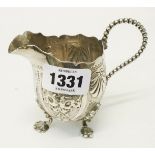 A Victorian silver cream jug with shaped rim, beaded handle and embossed decoration - Sheffield