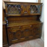 A 5' 20th Century polished oak two part sideboard in the antique style with flanking leaded glazed