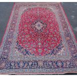 A large Middle Eastern rug with central medallion and spandrels on profuse floral red ground
