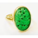 A marked 18ct. yellow metal ring, set with oval carved jade panel