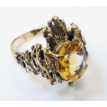 An unmarked late 1960's yellow metal bark/ pattern dress ring, set with large oval citrine