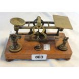An early 20th Century set of brass Postal scales and weights set on an oak base